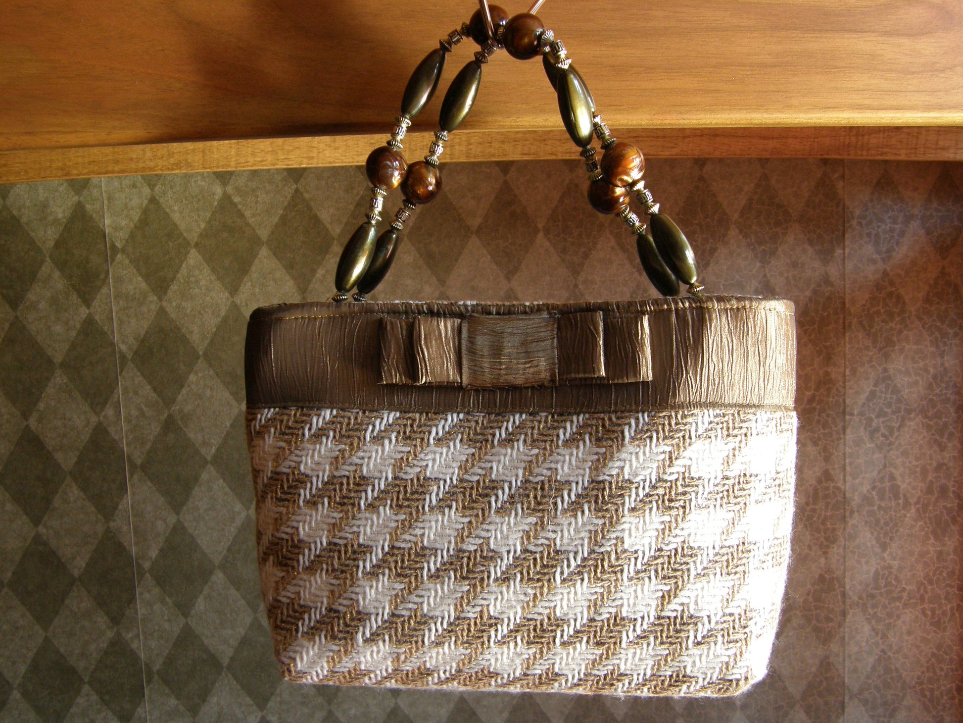 Beige and Gold Houndstooth Purse from Jenny Jagwear Design. Small ladies purse in 8" x 7" with gold and white houndstooth cloth fabric, gold tafetta trim and bow, with olive, gold and brown beaded handles.  Purse small enough to hold in your hand or use the handles. The Isabella Collection from Jenny Jag-Wear Design