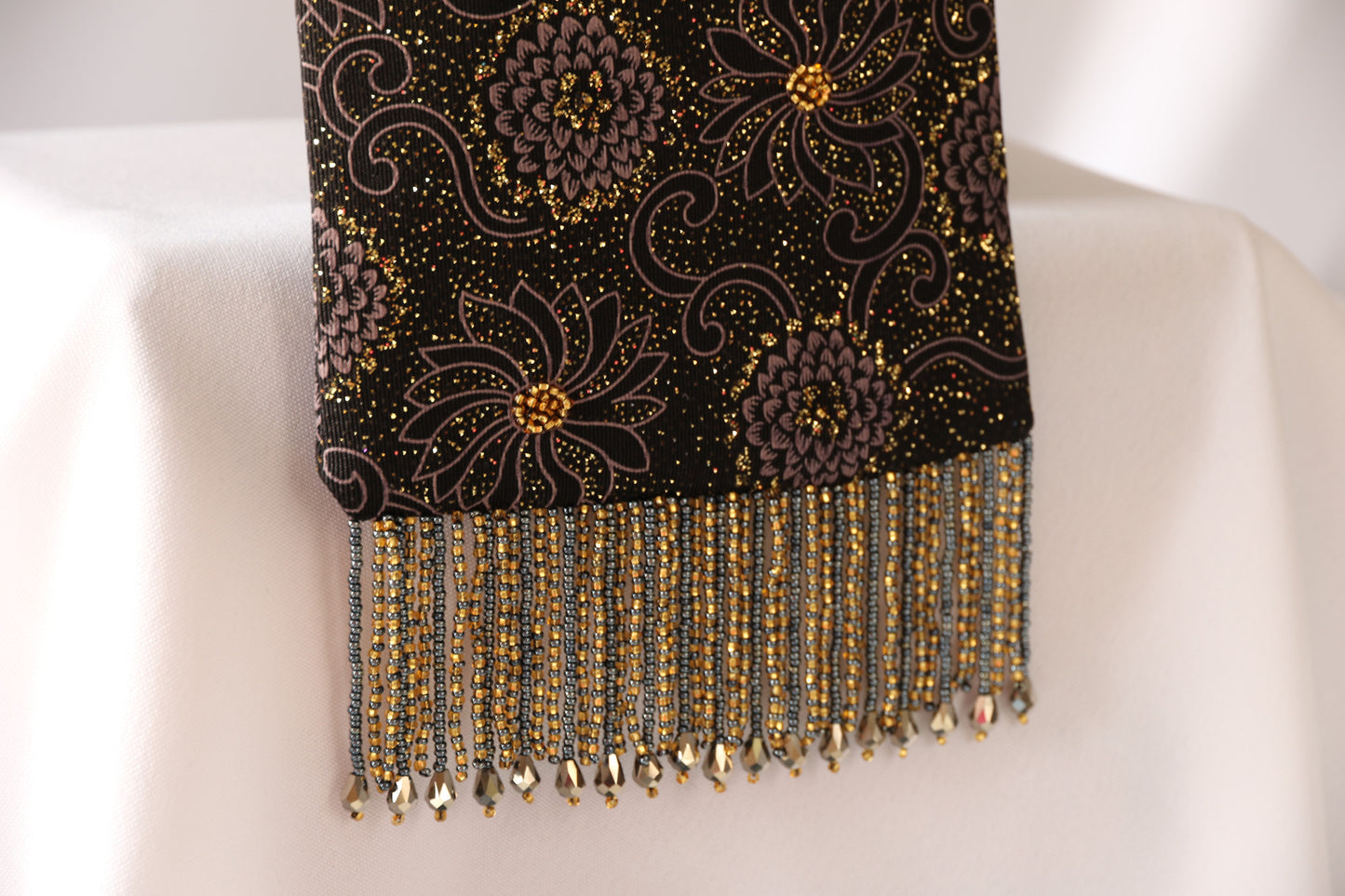Black and Gold Evening Bag from Jenny Jag-Wear Design. Photo demonstrates close-up of the gold, grey, black knit fabric and beaded fringe made from grey pearl tear drop beads, and gold and grey seed beads. The Zara Collection from Jenny Jag-Wear Design.