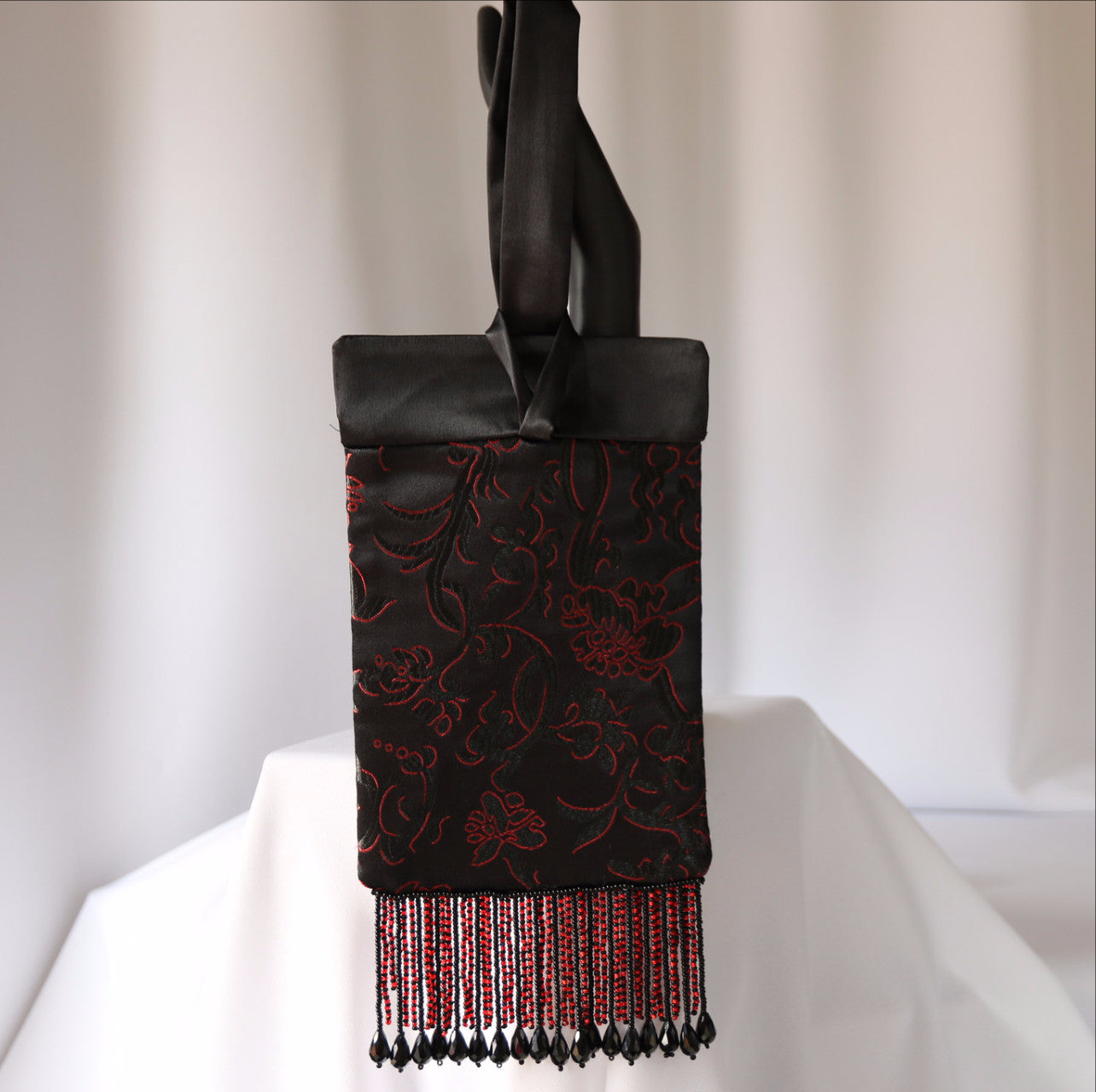Black and red evening bag with black satin lining and beaded fringe.