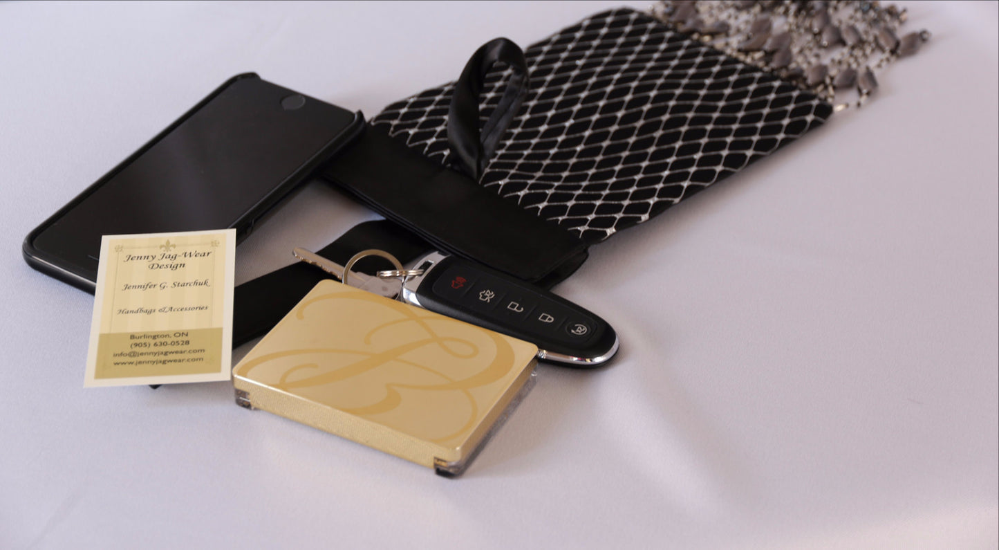 Black and Silver Evening Bag from Jenny Jag-Wear Design. Image shows the functionality of this seek and compact evening bag which can hold a compact case, car keys, lipstick and cell phone without compromise. The  Zara Collection from Jenny Jag-Wear Design.