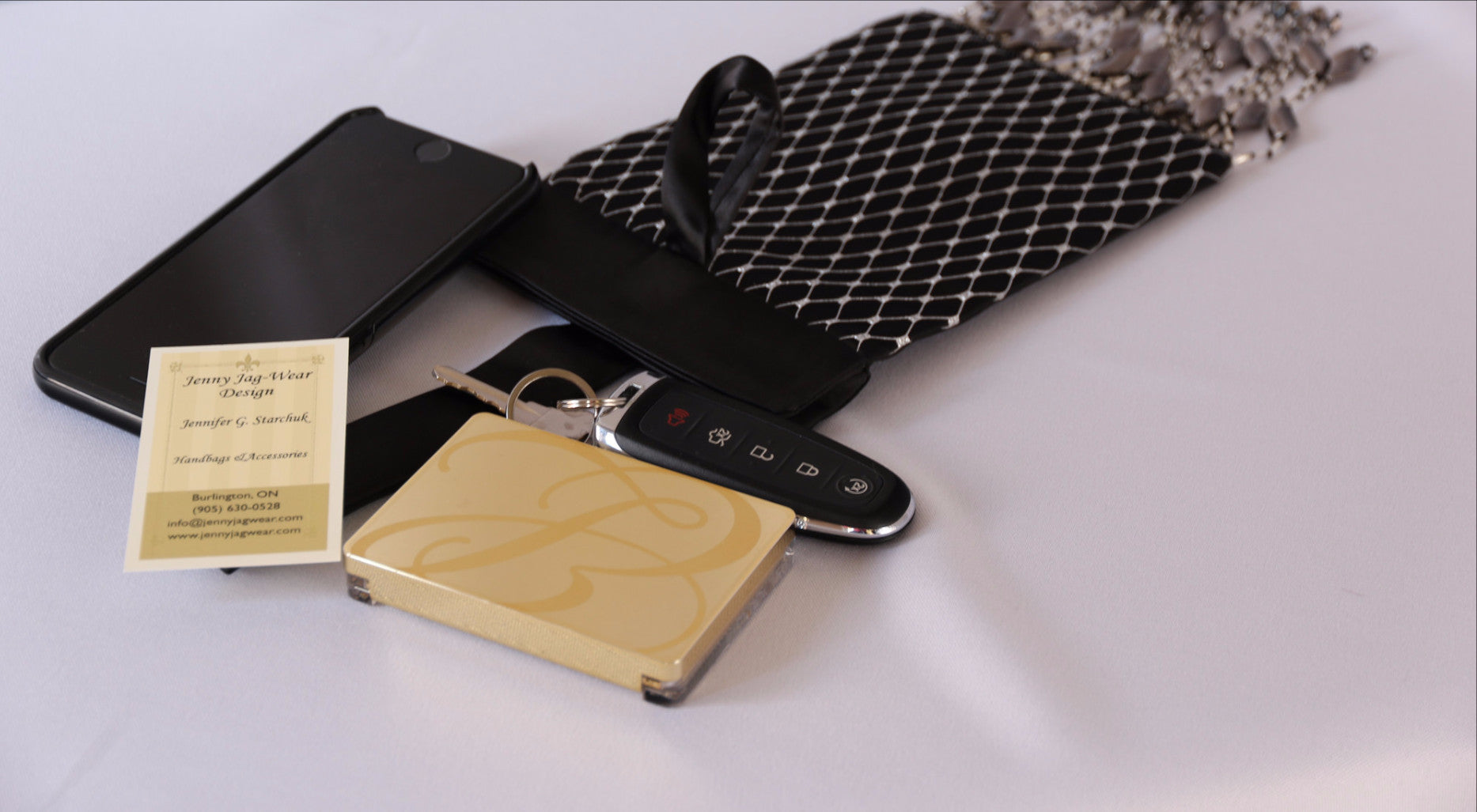 Black and Silver Evening Bag from Jenny Jag-Wear Design. Image shows the functionality of this seek and compact evening bag which can hold a compact case, car keys, lipstick and cell phone without compromise. The  Zara Collection from Jenny Jag-Wear Design.