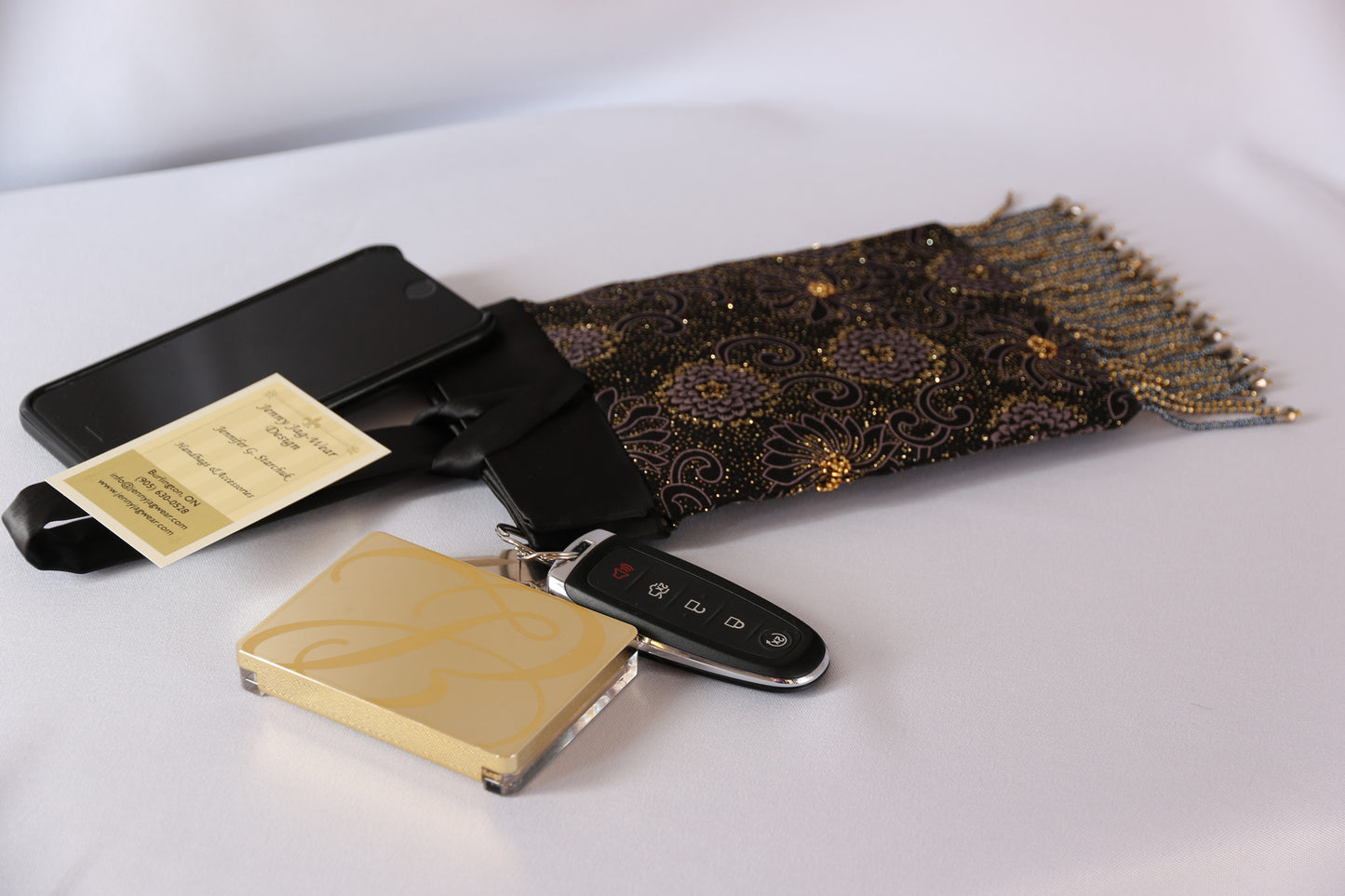Black and Gold Evening Bag from Jenny Jag-Wear Design. Photo demonstrates this compact and functional purse can easily hold a compact, car keys, lipstick tube and cell phone without compromise. The Zara Collection from Jenny Jag-Wear Design.
